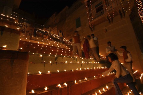 INDIA, Uttar Pradesh, Varanasi, Deep Diwali Festival. People lighting oil lamps on the steps