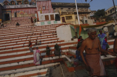 INDIA, Uttar Pradesh, Varanasi, Kedar Ghat. Hindu worshippers beside the Ganges River in the early
