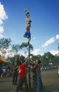 THAILAND, Chiang Mai, Samathi Mai, Kachin Manou. Kachin boy reaches the prize climbing a greased