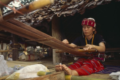 THAILAND, Chiang Mai, Sgaw Karen woman weaving cloth on a back strap loom