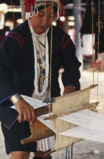 THAILAND, Chiang Mai Province, Akha woman weaving cloth on an Akha loom