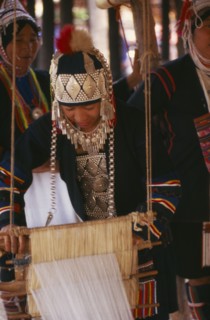 THAILAND, Chiang Mai Province, Akha woman weaving cloth on an Akha loom