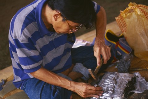 THAILAND, Chiang Mai, Wat Sri Suphan, Silversmith making repousse picture of elephants