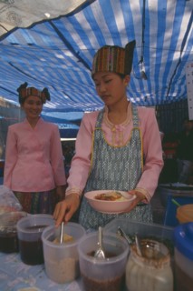 THAILAND, Chiang Mai, Wat Pa Pao, Two Shan women in traditional Shan attire at a food shop during