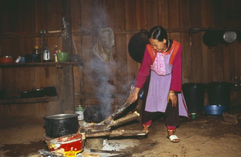 THAILAND, Chiang Mai Province, Chiang Dao District, Young Lisu woman working in her kitchen in Bahn