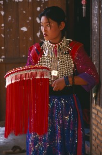 THAILAND, Chiang Rai Province, Doi Lan, Young Lisu woman in her New Year finery prior to going to a