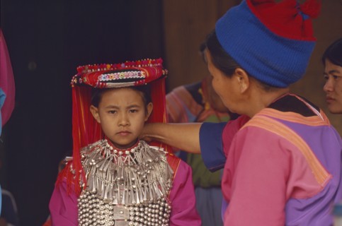 THAILAND, Chiang Rai Province, Huai Khrai, Young Lisu girl dressed in her New Year finery while her