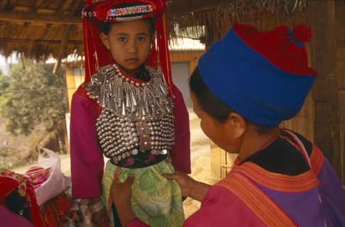 THAILAND, Chiang Rai Province, Huai Khrai, Young Lisu girl dressed in her New Year finery while her