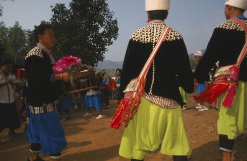 THAILAND, Chiang Rai Province, Huai Khrai, Lisu man carrying offerings to put by the New Year tree