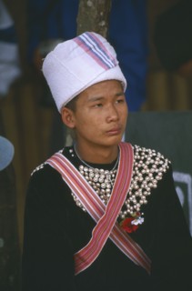 THAILAND, Chiang Rai Province, Doi Lan, Young Lisu man at New Year dance wearing his New Year