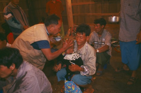 THAILAND, Chiang Rai Province, Doi Lan, Lisu shaman anointing supplicants head at healing ceremony