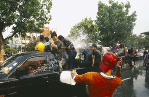 THAILAND, Chiang Mai, Songkran aka Thai New Year. Revellers in a pickup truck attempting to catch