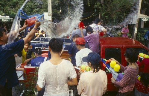 THAILAND, Chiang Mai, Songkran aka Thai New Year. Revellers in a pickup truck attempting to catch