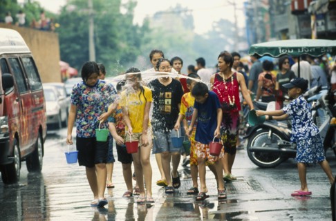 THAILAND, Chiang Mai, Songkran aka Thai New Year. Revellers having water thrown at them by a young