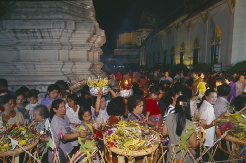 THAILAND, Chiang Mai, Wat Jedi Luang, Inthakhin Ceremony. People with offerings of flowers and joss