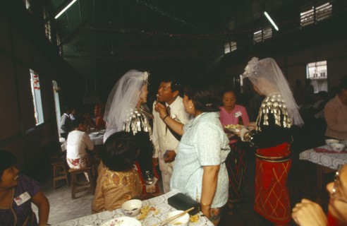 MYANMAR, Kachin State, Myitkyina, Jinghpaw wedding reception with Bridal couple and guests at the