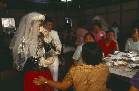 MYANMAR, Kachin State, Myitkyina, Jinghpaw wedding reception with Bridal couple and guests at the