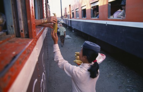 MYANMAR, Markets, Female vendor selling sweet corn to passengers on the Mandalay to Myitkyina train