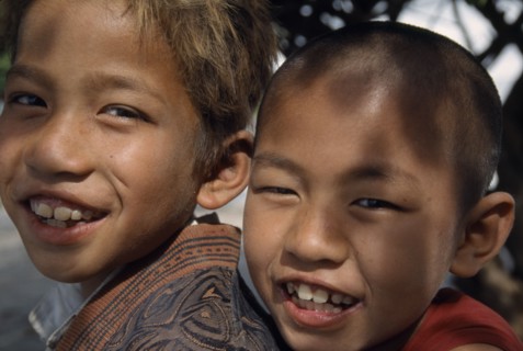 MYANMAR, Amarapura, Portrait of smiling novice monk and temple boy on Lake Taungthaman near