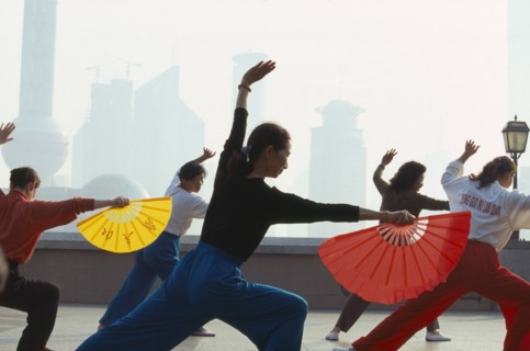 CHINA, Shanghai, Early morning group exercise using fans on the Bund.