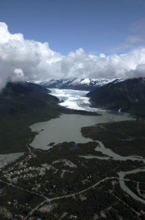 USA, Alaska, Juneau, Aerial view over town and waters leading toward snow covered valley and