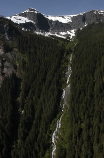 USA, Alaska, Misty Fjords Nat. Monument, Snow capped mountain tops with waterfall running down