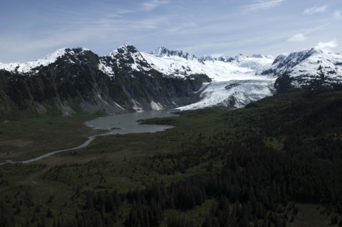 USA, Alaska, Prince William Sound, View over tree covered landscape toward waters and snow capped