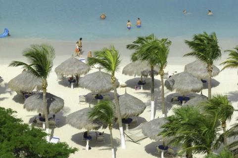 WEST INDIES, Dutch Antilles, Aruba, View looking down on white sandy beach lined with thatched