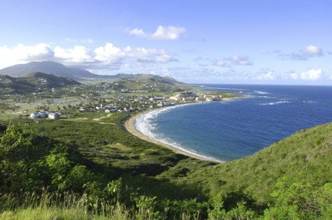 WEST INDIES, St Kitts, View over green hills and coastline with sandy bay