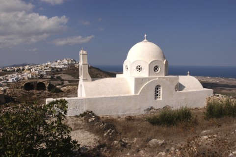 GREECE, Cyclades, Santorini, Whitewashed Church with domed roof overlooking the town