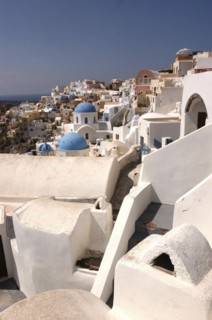 GREECE, Cyclades, Santorini, View over white town architecture with occasional blue domes