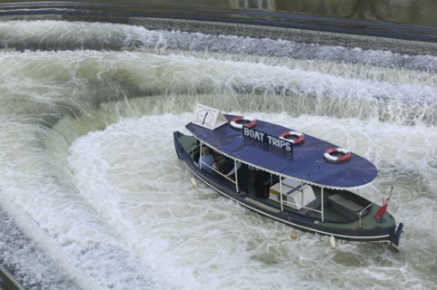ENGLAND, Bath, A pleasure boat in the weir beneath Pulteney Bridge.
