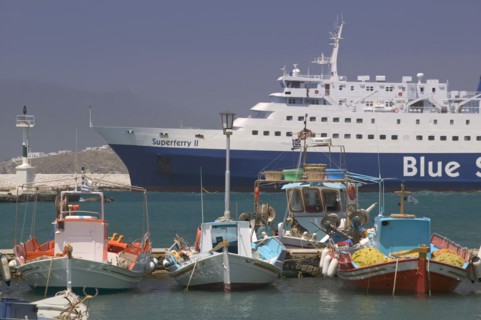 GREECE, Cyclades, Mykonos, Passenger ferry in port with colourful fishing boats in the foreground.