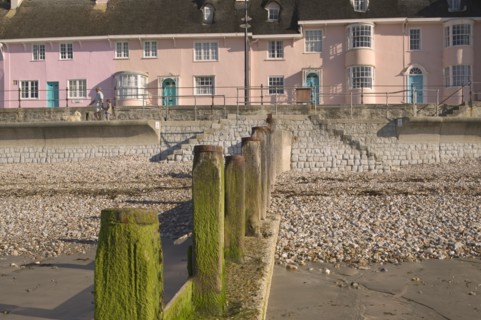 ENGLAND, Dorset, Lyme Regis, View of old fishermens cottages along the waterfront from the beach