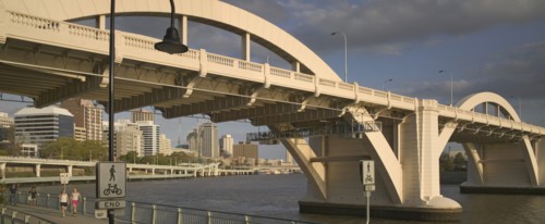 AUSTRALIA, Queensland, Brisbane, Walkers strolling along the River Walk beneath a road bridge over