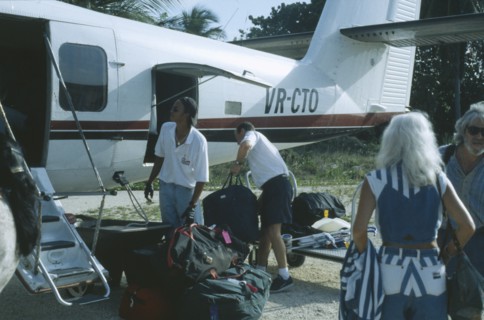 WEST INDIES, Cayman Islands, Little Cayman, Passenger plane with tourists on runway unpacking