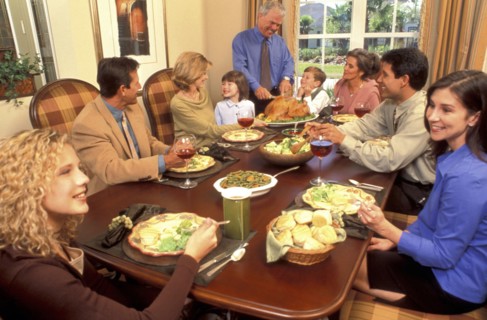 USA, People, Family eating a meal of roast turkey at the table