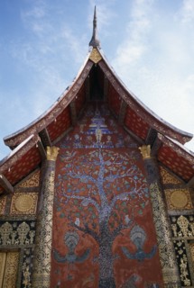 LAOS, Luang Prabang, Wat Xieng Thong.  Ornate temple exterior with Tree of Life mosaic and gold