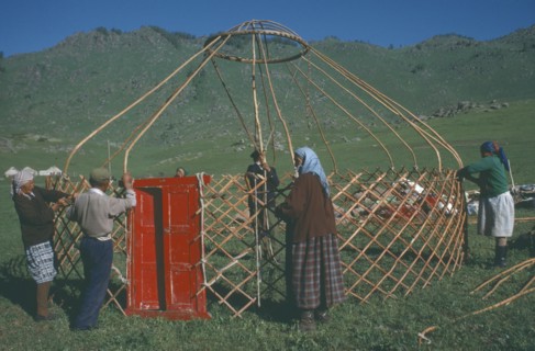 CHINA, Xinjiang, Altai Region, "Kazakh nomads building kigizuy, erecting circular frame and doorway