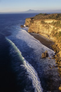INDONESIA, Bali, Coastline, View north at sunset from Uluwatu Temple along rocky coastline towards