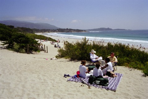 USA, California, Carmel, Carmel Beach with people on blanket among sand dunes in the foreground