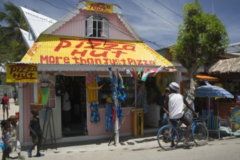 WEST INDIES, St Vincent & The Grenadines, Union Island, Men talking outside pizza restaurant and