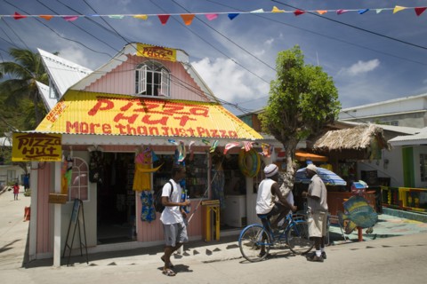 WEST INDIES, St Vincent & The Grenadines, Union Island, Men talking outside pizza restaurant and