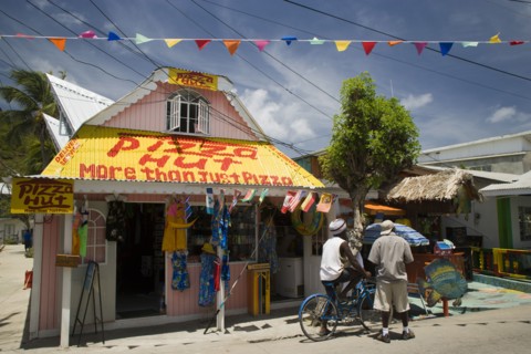 WEST INDIES, St Vincent & The Grenadines, Union Island, Men talking outside pizza restaurant and