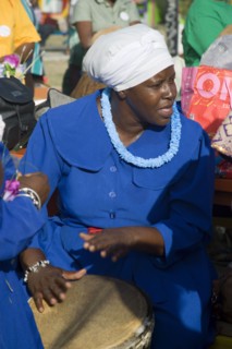 WEST INDIES, St Vincent & The Grenadines, Union Island, Woman playing a drum amongst the Baptist