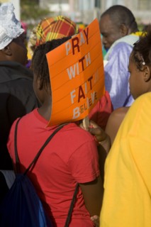 WEST INDIES, St Vincent & The Grenadines, Union Island, Woman carrying a religious placard amongst