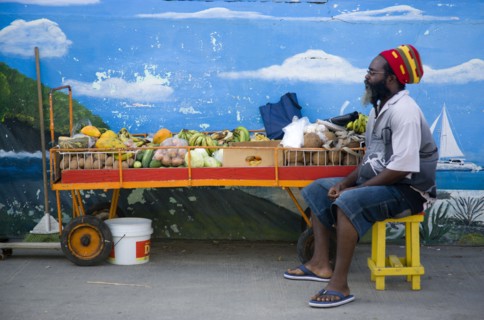 WEST INDIES, St Vincent & The Grenadines, Union Island, Fruit and vegetable stall holder in front