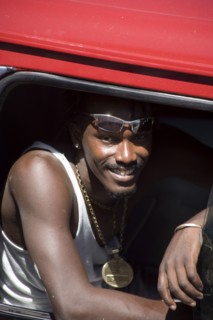 WEST INDIES, St Vincent & The Grenadines, Union Island, Young man in minibus wearing large golden