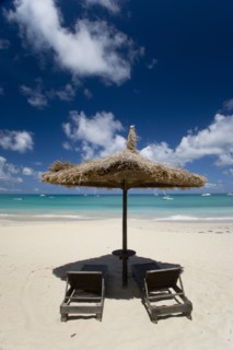 WEST INDIES, St Vincent & The Grenadines, Canouan, Palapa thatched shelter and sunbeds at Tamarind