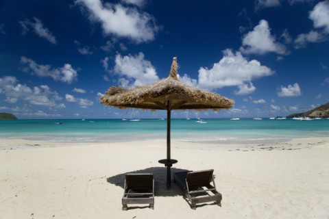 WEST INDIES, St Vincent & The Grenadines, Canouan, Palapa thatched shelter and sunbeds at Tamarind